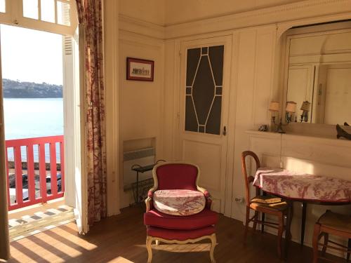 Cette chambre dispose d'une table, d'une chaise et d'un balcon. dans l'établissement Résidence Thiers Golf 2 -Charmant studio face à la baie, à Saint-Jean-de-Luz