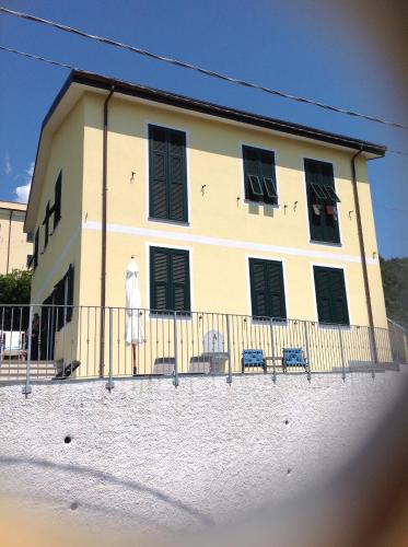 a building with chairs and a fence in front of it at Affittacamereirosmarini in Vernazza