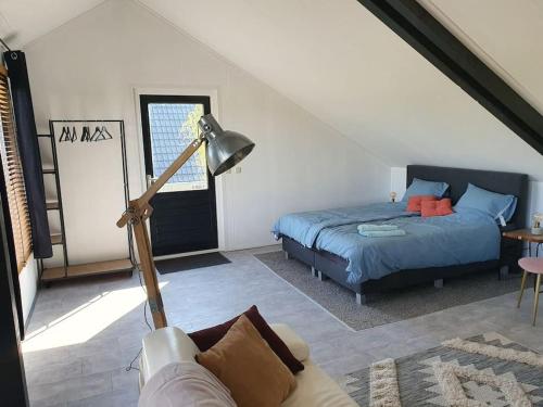 1 dormitorio con 1 cama, 1 sofá y 1 lámpara en Vrijstaand / landelijk appartement met uitzicht!, en De Wijk