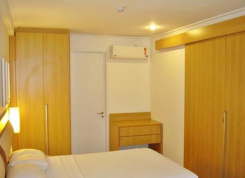 1 dormitorio con cama, armario y puerta en Flat no Beach Class Resort, en Porto de Galinhas