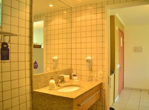 ein Badezimmer mit Waschbecken und Spiegel in der Unterkunft Flat no Beach Class Resort in Porto De Galinhas