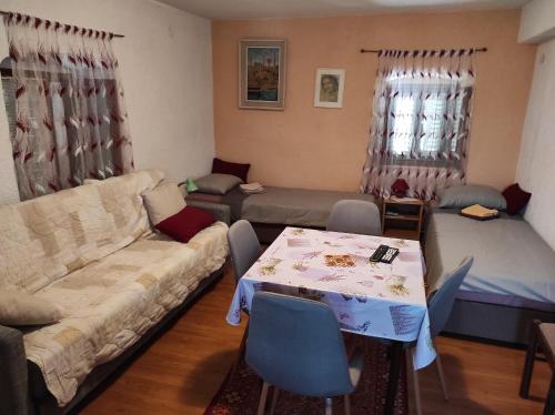 ein Wohnzimmer mit einem Sofa und einem Tisch in der Unterkunft Maja Apartment in Višnjan