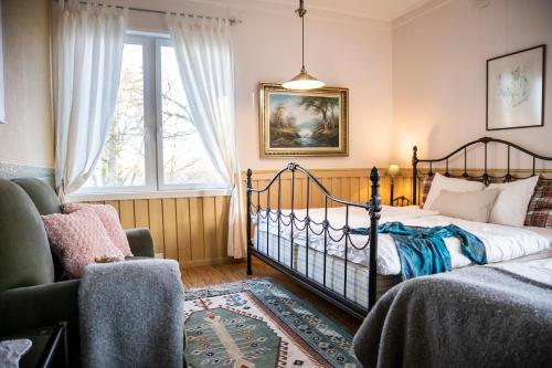 Un dormitorio con una cama y una silla y una ventana. en Skotteksgården Cottages, en Ulricehamn