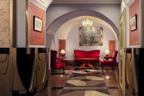 a living room with a red couch and red chairs at The Charles in Prague