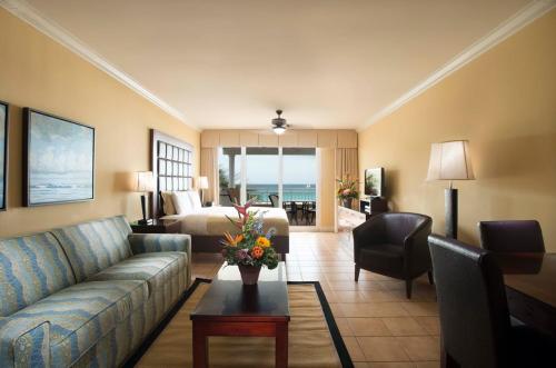 a living room with a couch and a room with a bed at All Inclusive - Divi Village Golf and Beach Resort in Palm-Eagle Beach
