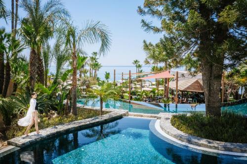a woman walks by the pool at the resort at Amathus Beach Hotel Limassol in Limassol