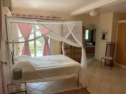 a bedroom with a bed with a canopy at La Maison de Jeanne et Léa in Somone