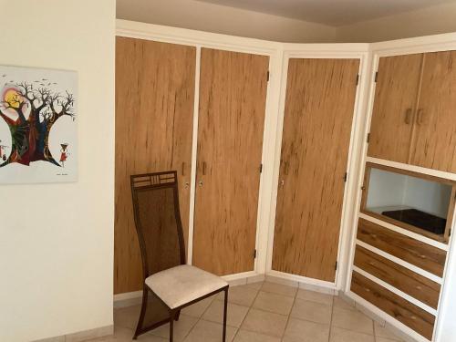 a room with wooden cabinets and a chair at La Maison de Jeanne et Léa in Somone