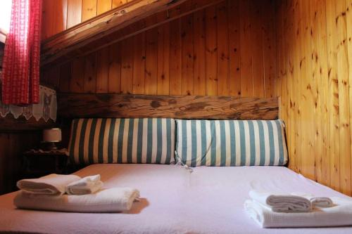una camera da letto con un letto e asciugamani di Appartamento nel cuore della Val di Sole a Commezzadura