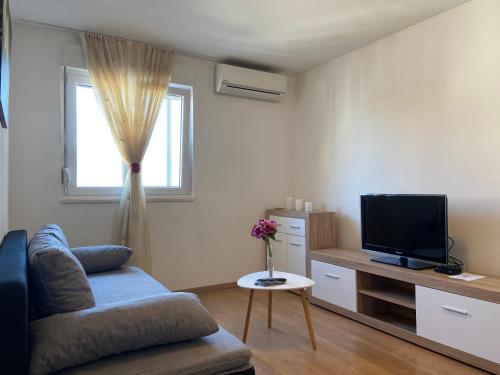 a living room with a couch and a television at Apartment Sućidar in Split