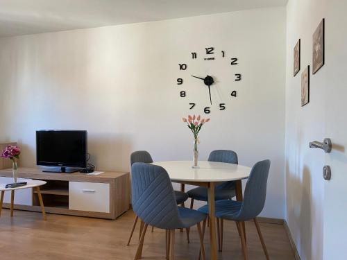 a dining room with a table and a clock on the wall at Apartment Sućidar in Split