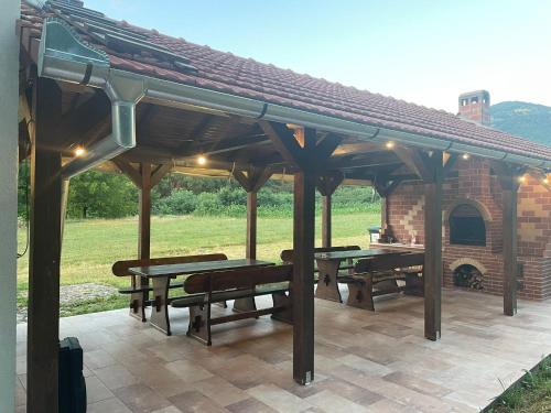 two picnic tables and benches under a pavilion at Hanul Ursilor in Chişcău