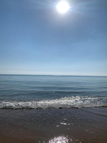 una spiaggia con l'oceano e il sole nel cielo di Apartamentoen la playa, 200 Mts de la playa Nuevo a Santa Pola
