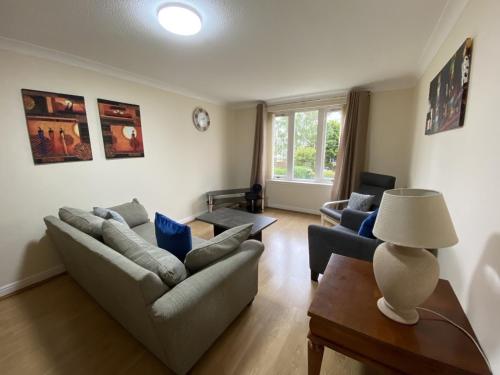 a living room with two couches and a table at Pure Apartments Dunfermline East - Dalgety Bay in Saint Davids