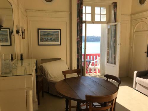 Cette chambre comprend une table, un lit et une fenêtre. dans l'établissement Résidence Thiers Golf 1 -Charmant studio face à la baie, à Saint-Jean-de-Luz