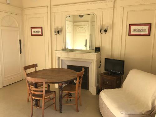 Cette chambre comprend une table, un lit et un miroir. dans l'établissement Résidence Thiers Golf 1 -Charmant studio face à la baie, à Saint-Jean-de-Luz