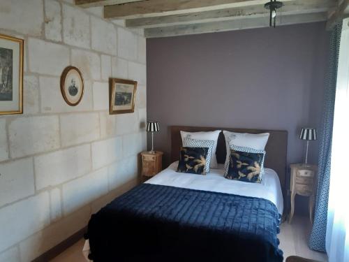 a bedroom with a bed with blue sheets and pillows at Agréables chambres d'hôtes dans maison XVIIIe in Vineuil