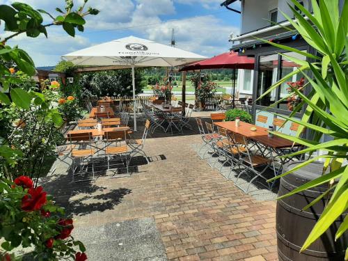 a patio with tables and chairs and an umbrella at Chambtaler Hof in Runding