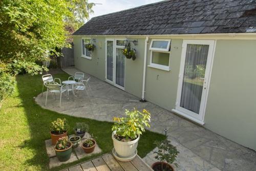 um quintal de uma casa com vasos de plantas e um pátio em Bramlies Bed & Breakfast em Dorchester