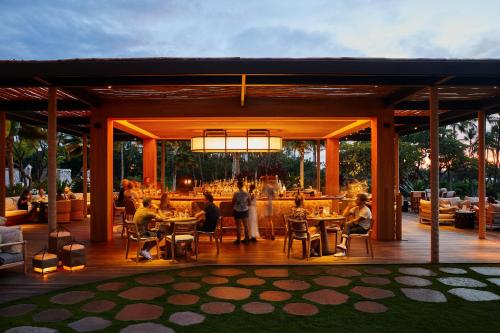 um restaurante com pessoas sentadas em mesas num deque em Mauna Lani, Auberge Resorts Collection em Waikoloa