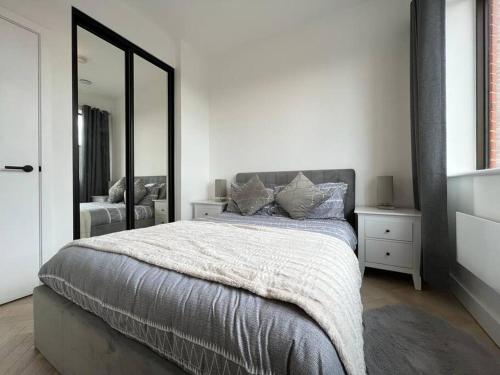 a bedroom with a large bed and a mirror at STYLISH 1 BED & PARKING-IDEAL FOR CORPORATE STAYS - By Tempstay in Slough