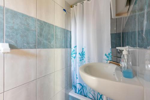 a bathroom with a sink and a shower curtain at Apartment Nada in Mundanije