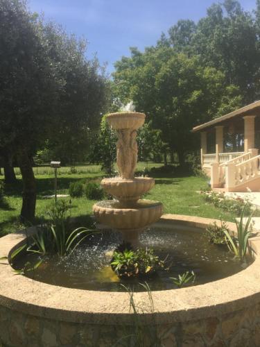 a fountain in the middle of a yard at B&B gite d'Ayran in Saint-Quentin-la-Poterie