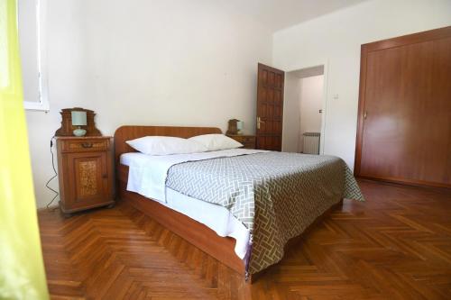 um quarto com uma cama e piso em madeira em City center. Beautiful 130m2 apartmant, sea view em Zadar