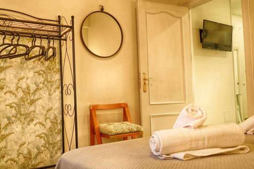 1 dormitorio con cama, espejo y silla en Apartamento zona Aeropuerto, Ifema y Bernabeu, en Madrid