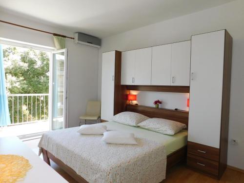 a bedroom with two beds and a large window at Apartment Dalmatia Ketty in Makarska