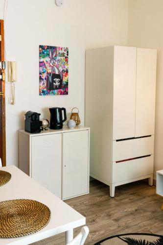 Cette chambre comprend une armoire blanche et une table. dans l'établissement Apart Nissa Bella Centre / Promenade des Anglais, à Nice