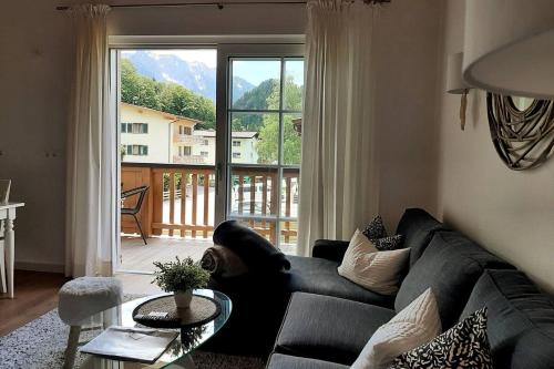 a living room with a couch and a large window at Ferienhaus Kaiserblick - FEWO2 in Walchsee