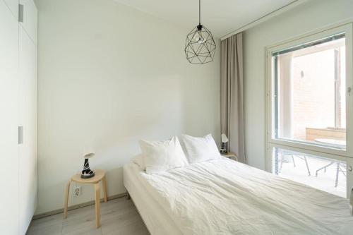 a white bedroom with a bed and a window at Haven Homes, Nordic Haven in Rovaniemi