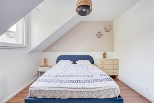 ein Schlafzimmer mit einem blauen Bett in einem Dachgeschoss in der Unterkunft Cosy House - Disney & Paris - Near Train in Bussy-Saint-Georges