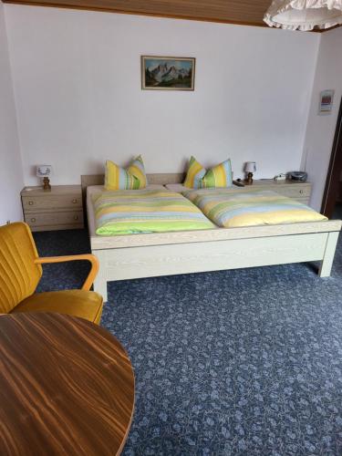 a bedroom with a white bed with colorful pillows at Hotel Zur Schanze in Wieda