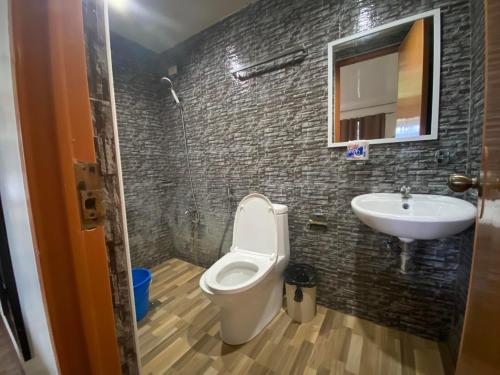 a bathroom with a toilet and a sink at Road Garden Villa in General Luna