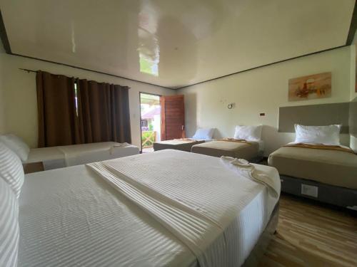 a hotel room with two beds and a window at Road Garden Villa in General Luna