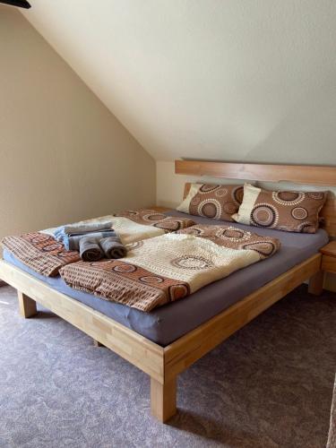 a bed with a wooden frame in a room at Haus Petra in Stadtkyll