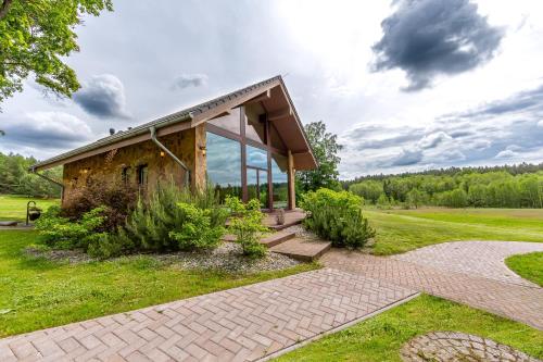 a pavilion with a brick walkway in front of a building at Harmony Park Countryside Villas & SPA in Prienai