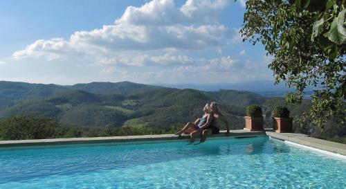 a woman sitting on the edge of a swimming pool at Podere Capitignano in Borgo San Lorenzo