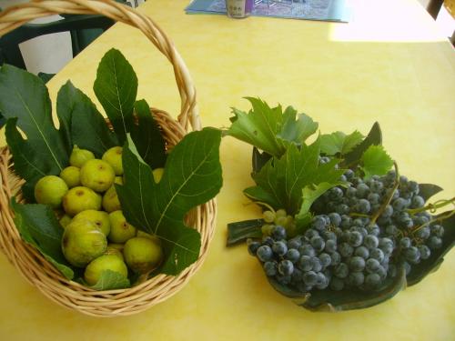 two baskets of grapes and pears on a table at Apartmani Braut in Kornić