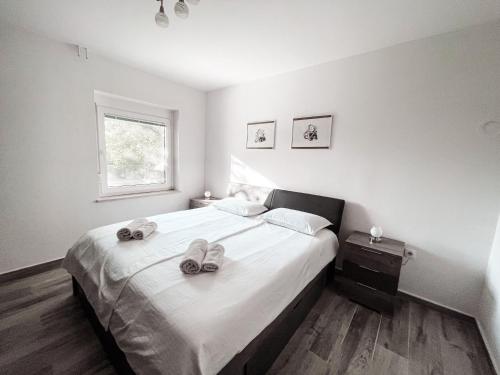 a bedroom with a bed with two slippers on it at RIAD Apartments Premium in Zgornje Škofije