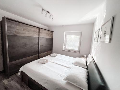 a bedroom with a large bed with white sheets at RIAD Apartments Premium in Zgornje Škofije