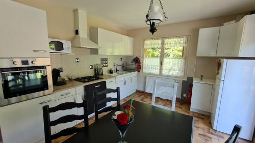 d'une cuisine avec des placards blancs et une table avec des fraises. dans l'établissement La Préférence, à Saint-Aignan
