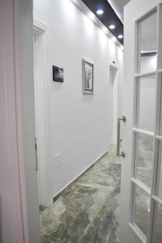 a hallway with a white door and a tile floor at HotelApart - DelMar in Durrës