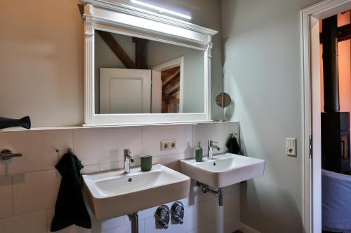 a bathroom with two sinks and a mirror at Storchenhof Blumenow in Blumenow