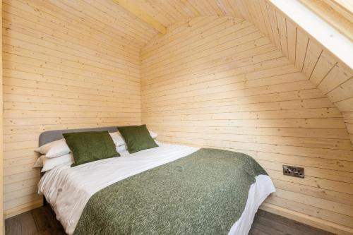 una camera da letto con letto in una camera in legno di Parkgate Farm a Holmrook