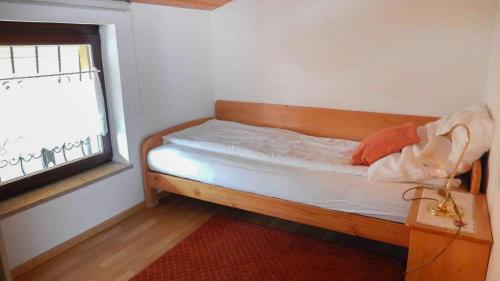 a small bedroom with a bed with a window at Ferienwohnungen am Hasenweg in Ruhstorf