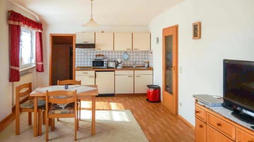 a kitchen and dining room with a table and a television at Ferienwohnungen am Hasenweg in Ruhstorf