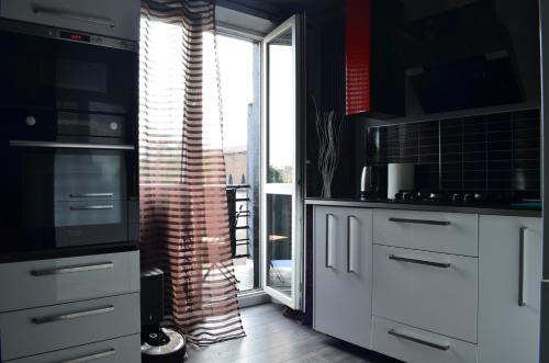 a kitchen with white cabinets and a large window at Apartment in the City Center - FREE PARKING - easy check-in in Chorzów